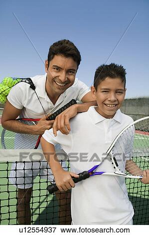 Father and son standing at net on tennis court, portrait View Large Photo Image Stock Photo - Father and son standing at net on tennis court, portrait. Fotosearch