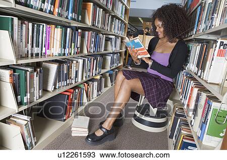 Female college student reading in library View Large Photo Image Stock Image - Female college student reading in library. Fotosearch