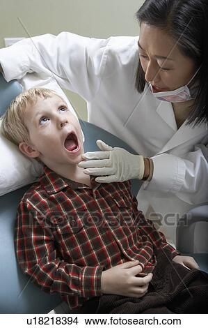 Female dentist examining boy (6-9) in surgery View Large Photo Image Picture - Female dentist examining boy (6-9) in surgery. Fotosearch