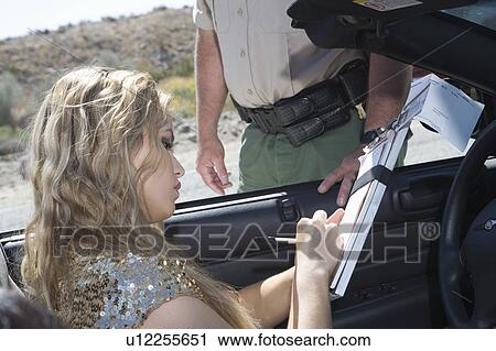Stock Image - Female driver fills in police details. Fotosearch