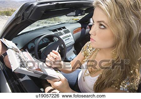 Stock Photograph - Female driver fills in speeding tcket. Fotosearch