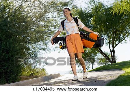 Female golfer carrying golf bag down path View Large Photo Image Stock Photography - Female golfer carrying golf bag down path. Fotosearch