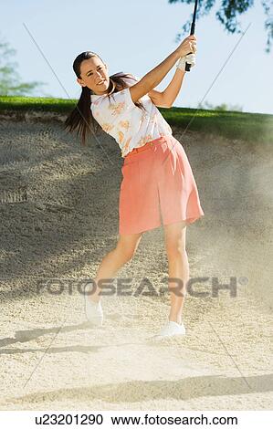 Female golfer hitting ball from sand trap View Large Photo Image Stock Image - Female golfer hitting ball from sand trap. Fotosearch