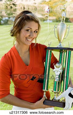 Female golfer holding trophy, (portrait) View Large Photo Image Stock Photograph - Female golfer holding trophy, (portrait). Fotosearch