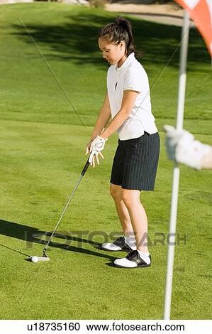Female golfer putting on green View Large Photo Image Stock Image - Female golfer putting on green. Fotosearch