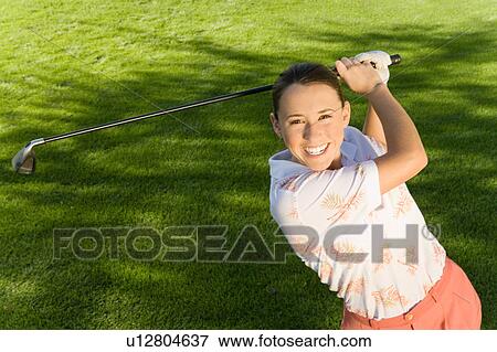 Female golfer swinging golf club, (elevated view), (portrait) View Large Photo Image Stock Photo - Female golfer swinging golf club, (elevated view), (portrait). Fotosearch