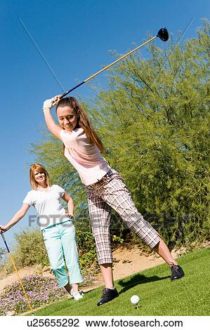Female golfer teeing off View Large Photo Image Stock Image - Female golfer teeing off. Fotosearch