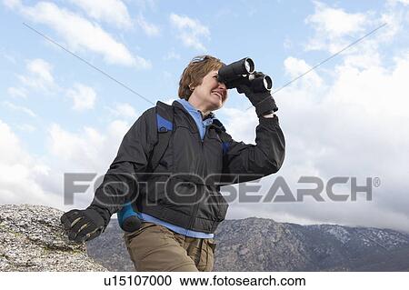 Female hiker using binoculars in mountains View Large Photo Image Stock Image - Female hiker using binoculars in mountains. Fotosearch