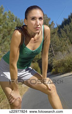 Picture - Female jogger pausing for breath on path. Fotosearch