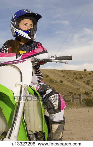 Stock Photograph - Female motocross racer on bike in desert. Fotosearch