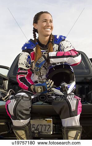 Stock Image - Female motocross racer, outdoors. Fotosearch