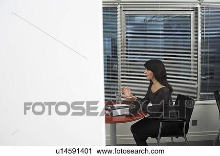 Female office worker sitting at table, gesturing, side view View Large Photo Image Stock Image - Female office worker sitting at table, gesturing, side view. Fotosearch