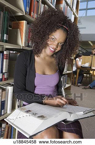 Female student making notes in library View Large Photo Image Stock Photo - Female student making notes in library. Fotosearch