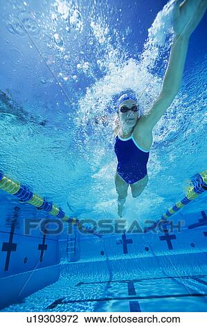 Female swimmer racing underwater in pool View Large Photo Image Stock Image - Female swimmer racing underwater in pool. Fotosearch
