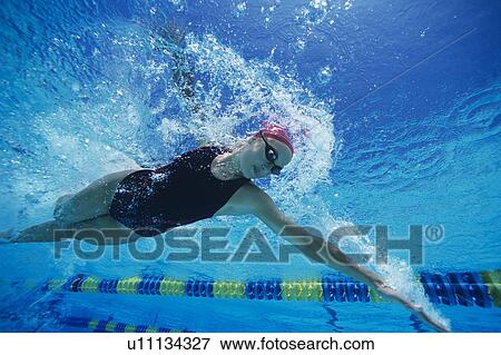 Stock Photo - Female swimmer racing underwater in pool. Fotosearch