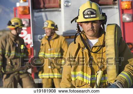 Stock Photo - Firefighter carrying hose. Fotosearch