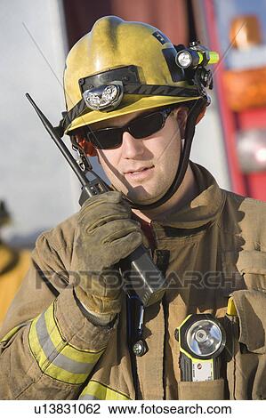 Firefighter holding two-way radio View Large Photo Image Stock Image - Firefighter holding two-way radio. Fotosearch