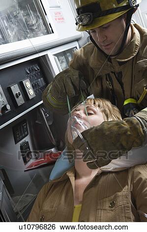 Firefighter holds mask over crash victim View Large Photo Image Stock Photograph - Firefighter holds mask over crash victim. Fotosearch