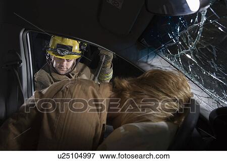 Stock Photo - Firefighter rescuing car accident victim. Fotosearch