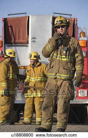 Firefighter using walkie talkie by fire engine View Large Photo Image Stock Image - Firefighter using walkie talkie by fire engine. Fotosearch