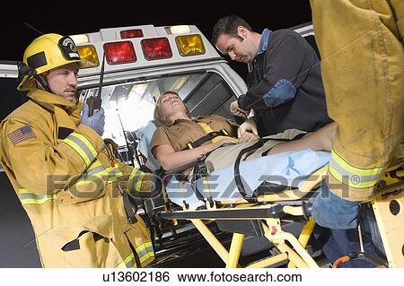Firefighters and paramedic lifting woman into ambulance View Large Photo Image Stock Photograph - Firefighters and paramedic lifting woman into ambulance. Fotosearch