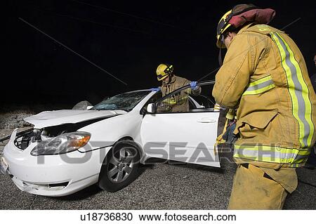 Firefighters examine car after crash View Large Photo Image Stock Image - Firefighters examine car after crash. Fotosearch