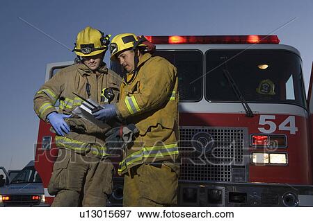 Firefighters planning rescue by fire engine View Large Photo Image Stock Photo - Firefighters planning rescue by fire engine. Fotosearch