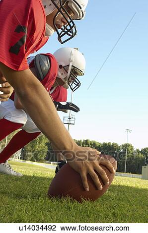 Football centre waiting to snap on field, side view View Large Photo Image Stock Image - Football centre waiting to snap on field, side view. Fotosearch