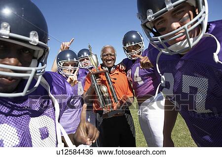 Football Coach and Players holding trophy on field, portrait, (portrait) View Large Photo Image Stock Photograph - Football Coach and Players holding trophy on field, portrait, (portrait). Fotosearch
