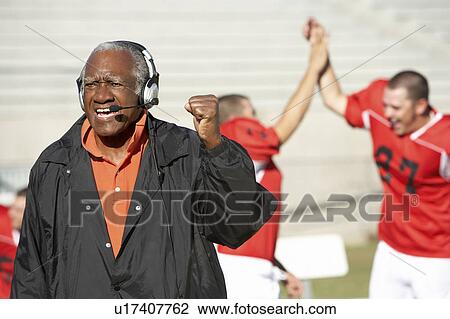 Football coach shouting and pumping fist on sideline View Large Photo Image Stock Image - Football coach shouting and pumping fist on sideline. Fotosearch