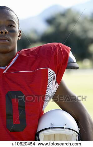 Football Player holding helmet on field, cropped View Large Photo Image Picture - Football Player holding helmet on field, cropped. Fotosearch