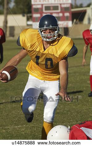 Football player running with ball on field View Large Photo Image Stock Photo - Football player running with ball on field. Fotosearch