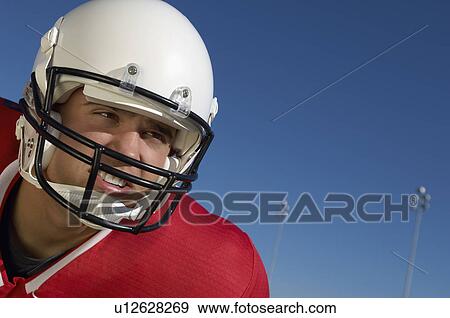 Stock Photo - Football Player wearing helmet on field, close-up, portrait, (close-up), (portrait). Fotosearch