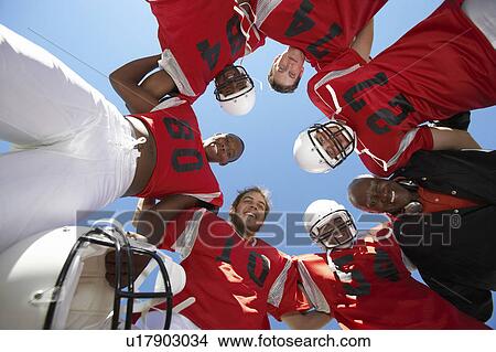 Picture - Football Players and Coach in Huddle, view from below, (view from below). Fotosearch