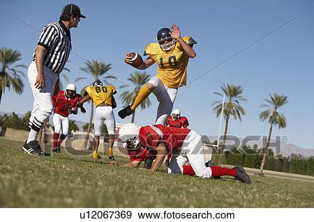 Stock Photo - Football players in action on field, ground view. Fotosearch