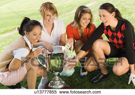 Four female golfers crouching around trophy, (elevated view) View Large Photo Image Stock Photography - Four female golfers crouching around trophy, (elevated view). Fotosearch