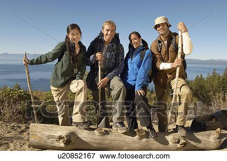 Stock Photo - Four friends hiking at coast, (portrait). Fotosearch
