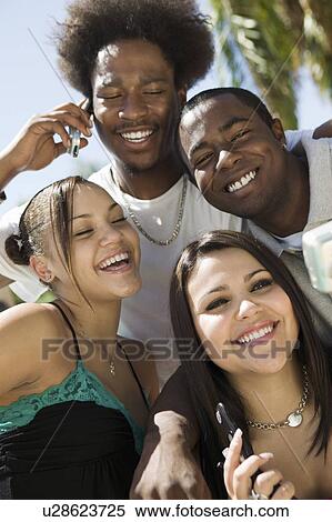 Four friends with mobile phones, portrait View Large Photo Image Stock Photography - Four friends with mobile phones, portrait. Fotosearch