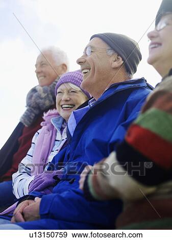 Four senior friends sitting outdoors, laughing View Large Photo Image Stock Photo - Four senior friends sitting outdoors, laughing. Fotosearch