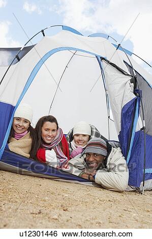 Four young adults lying down in small tent. View Large Photo Image Stock Photograph - Four young adults lying down in small tent.. Fotosearch