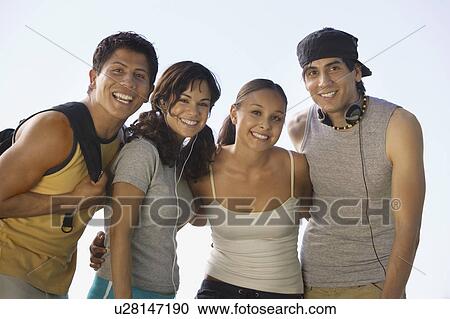 Stock Image - Four young adults outdoors.. Fotosearch