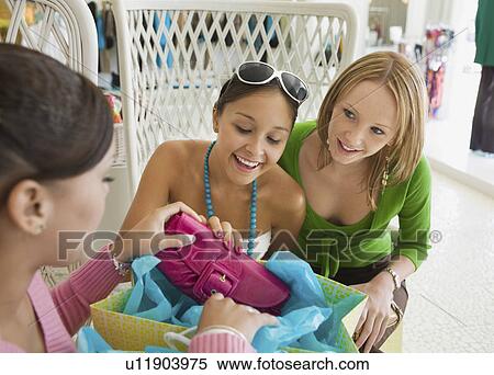 Friends Looking at Shopping Purchases View Large Photo Image Stock Photography - Friends Looking at Shopping Purchases. Fotosearch