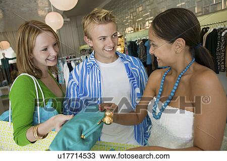 Stock Image - Friends Shopping at Clothing Store. Fotosearch