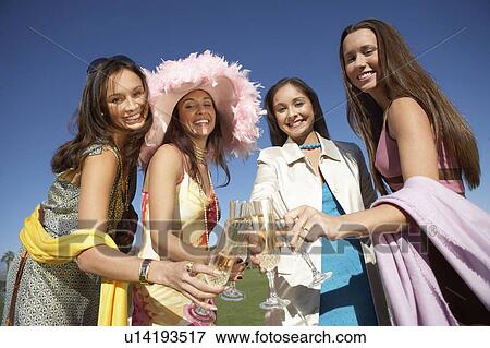 Stock Photo - Friends toasting, Celebrating with Champagne outdoors, low angle view. Fotosearch