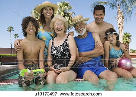 Stock Photo - Girl (10-12) with brother (13-15), parents, and grandparents at swimming pool, portrait.. Fotosearch