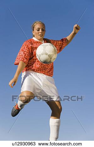 Girl (13-17) kicking soccer ball, portrait View Large Photo Image Stock Image - Girl (13-17) kicking soccer ball, portrait. Fotosearch