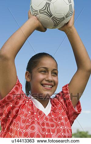 Stock Image - Girl (13-17) throwing in soccer ball, portrait. Fotosearch