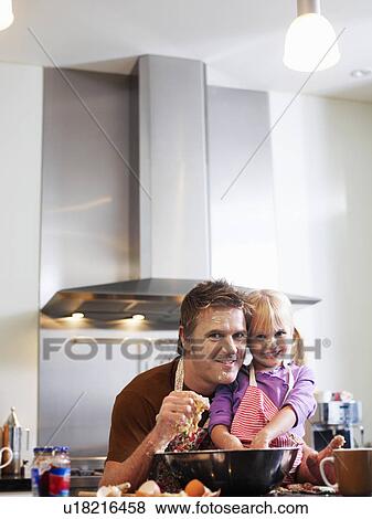 Stock Photo - Girl (3-4) and father baking in kitchen, portrait. Fotosearch