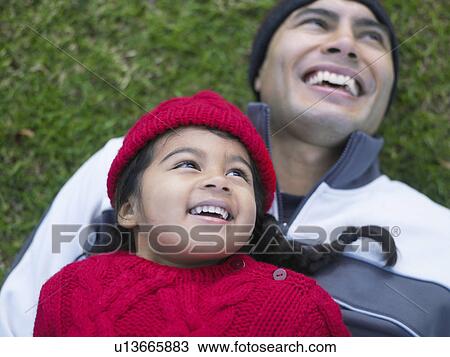 Girl (3-4) lying on top of father in grass, elevated view View Large Photo Image Stock Image - Girl (3-4) lying on top of father in grass, elevated view. Fotosearch