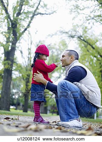 Girl (3-4) playing with father in park View Large Photo Image Picture - Girl (3-4) playing with father in park. Fotosearch